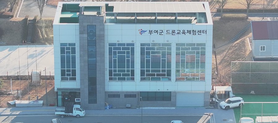 부여군 드론교육체험센터 건물을 상공에서 내려다본 모습 — 정면 벽에 센터 이름이 붙어 있다